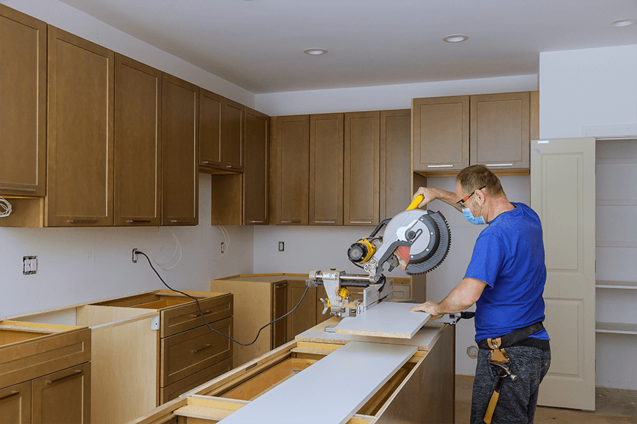 Construction worker using chop saw while remodeling residential kitchen - Decatur, IL
